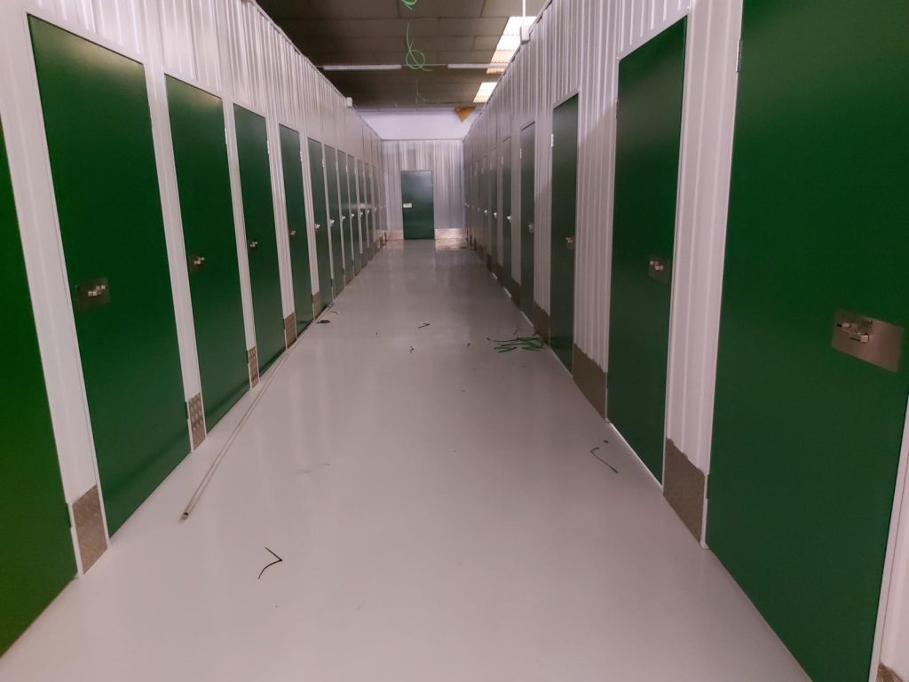 Pasillo de minialmacenes con puertas verdes en Valladolid